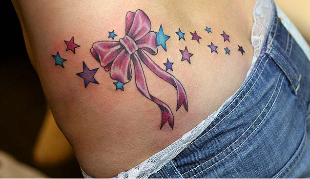 Apatinės nugaros juostelės lanko tatuiruotė su žvaigždėmis