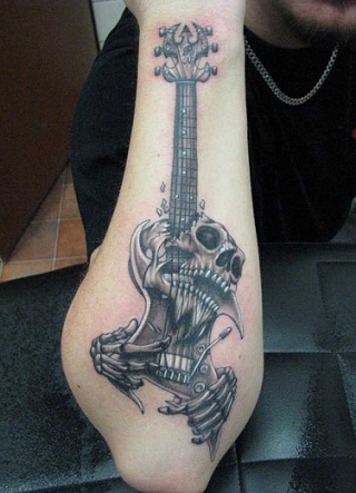 Kaukolė groja gitara tatuiruotė ant dešinės rankos