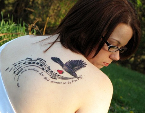 Paukščių tatuiruotė su muzikos simboliais