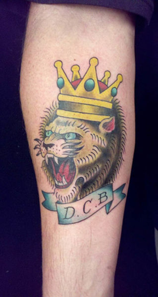 Riaumojančio liūto veido tatuiruotė su karūna