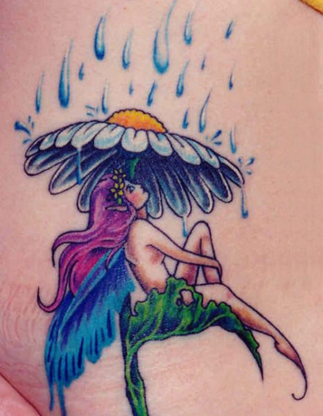 Fėja sėdi po lietaus fėjos tatuiruote