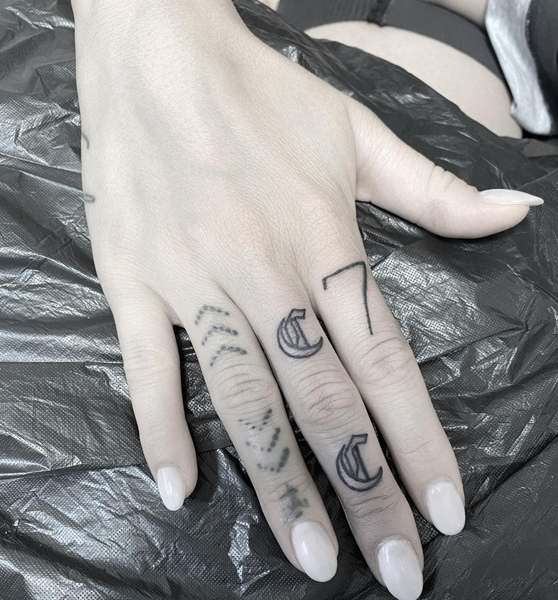 C raidės tatuiruotės dizainas ant vidurinio piršto