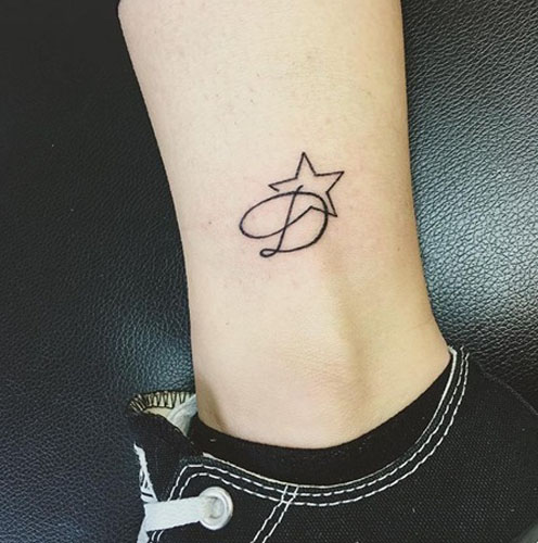 D raidės tatuiruotė su žvaigžde ant kulkšnies