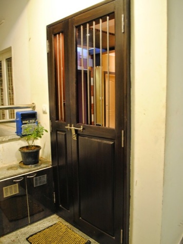 Tikmedžio medinės durys su geležinėmis grotelėmis