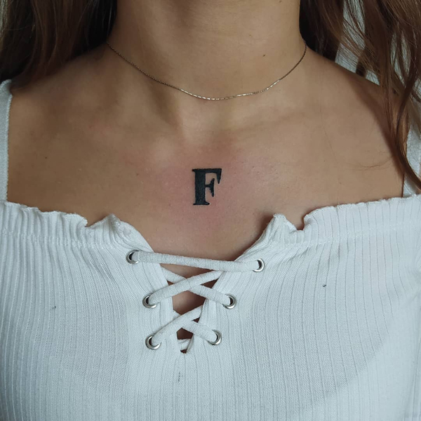 Paryškinta F raidžių tatuiruotė
