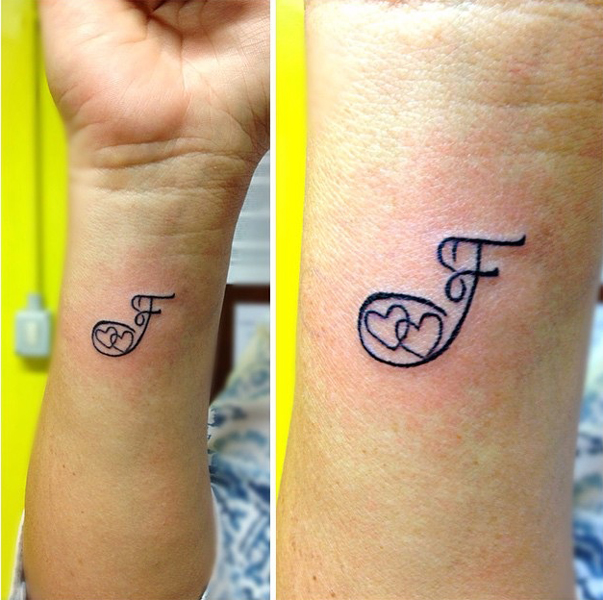 F raidžių tatuiruotė su dviem širdimis