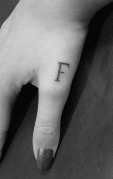 F raidės tatuiruotė ant nykščio