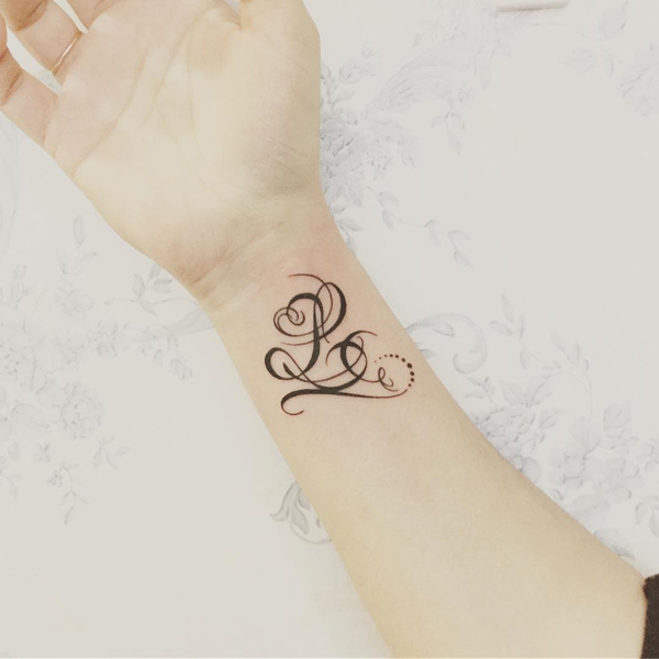 Stilinga L raidės tatuiruotė ant riešo