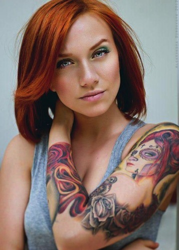 Nuožmios išvaizdos moters tatuiruotė visomis rankovėmis