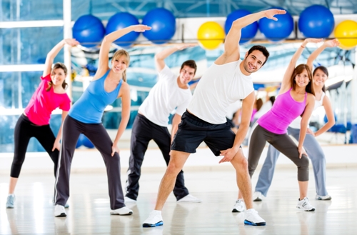 Žmonių grupė aerobikos pamokoje sporto salėje
