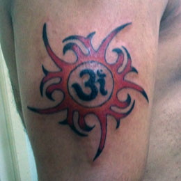 Genties saulės tatuiruotė su „Om“ simboliu centre