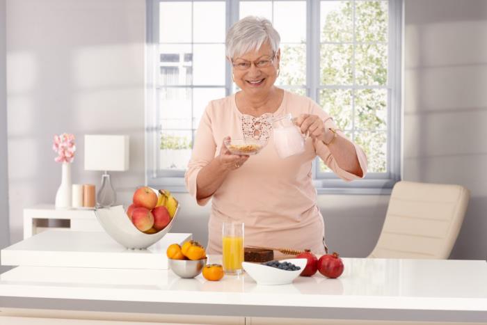 Χάστε βάρος ηλικιωμένη γυναίκα στην κουζίνα ξεκινήστε τη μέρα σας με ελαφρύ χυμό πρωινού με πολλά φρούτα