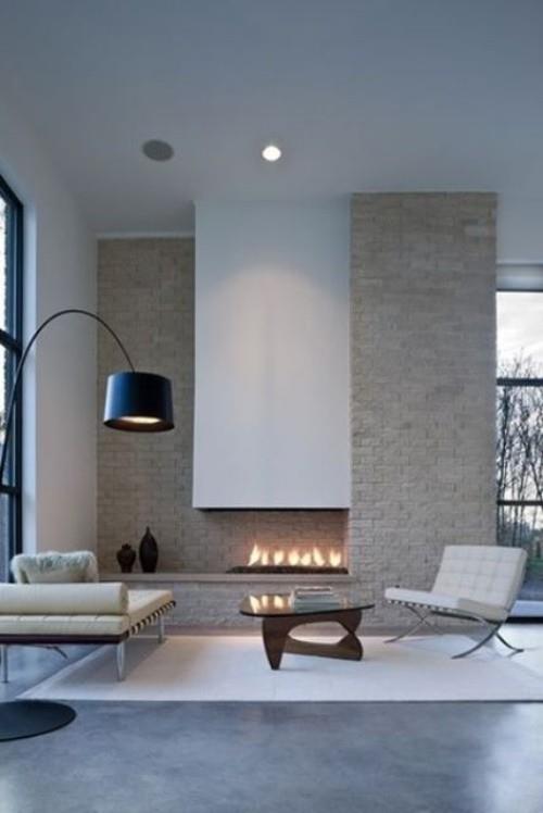Ασυμμετρία στο εσωτερικό εντοιχισμένο τζάκι πέτρινο τοίχο μοντέρνο κομψό φωτιστικό τόξου σχεδιασμού δωματίου