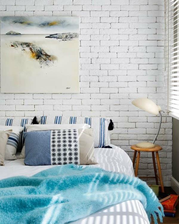 Ο τοίχος από τούβλα στο υπνοδωμάτιο βαμμένο σε λευκό δίνει έμφαση στην ήρεμη ατμόσφαιρα ρουστίκ ταλέντο τοιχογραφικό νυχτερινό φωτιστικό σκαμπό