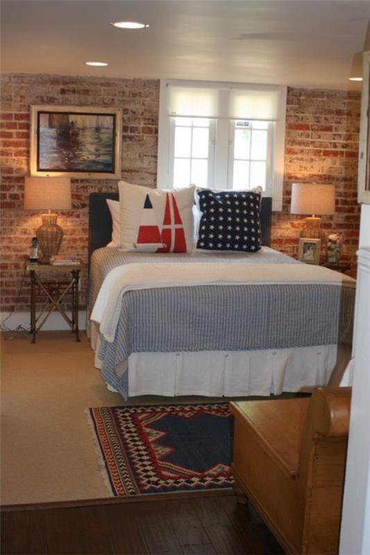 Τουβλότοιχος στο υπνοδωμάτιο με ρουστίκ πινελιές καλός φωτισμός διακοσμητικά μαξιλάρια υψηλού κρεβατιού