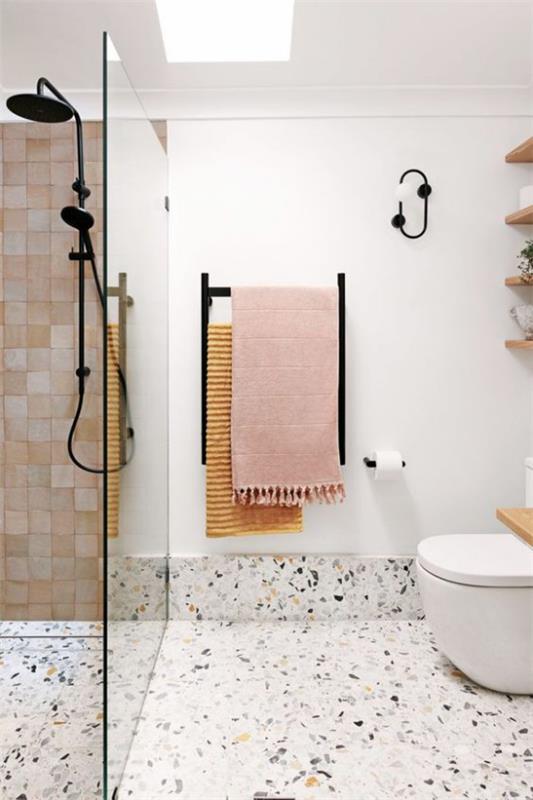 Τάσεις του μπάνιου 2021 terrazzo δάπεδο λευκοί τοίχοι μοντέρνο μπάνιο ντους γωνία γυάλινος τοίχος τουαλέτας πολύχρωμες πετσέτες