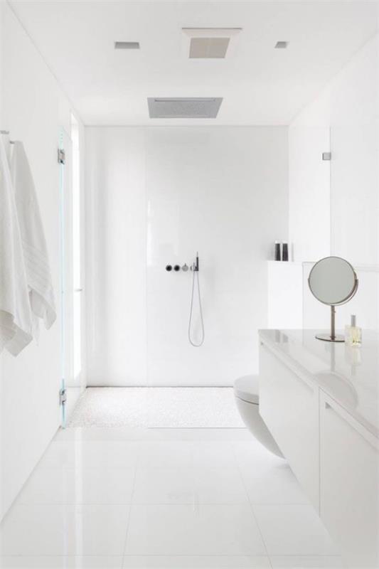 Μπάνιο σε λευκό χρώμα. Καθαρός μινιμαλισμός, λευκές πετσέτες, μικροί στρογγυλοί καθρέφτες