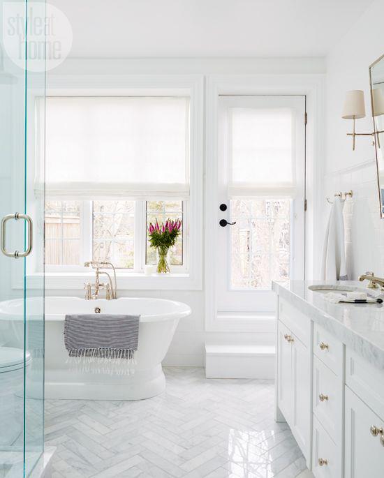 Μπάνιο όλα σε λευκό κομψό μπάνιο σχεδιάζουν ένα κομψό βάζο με πολύχρωμα λουλούδια δίπλα στο παράθυρο