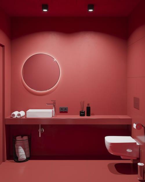 Μπάνιο σε κόκκινη τουαλέτα λευκό νεροχύτη νεροχύτη λευκές πετσέτες όλα τα άλλα κόκκινο δροσερό φωτισμό στρογγυλό καθρέφτη