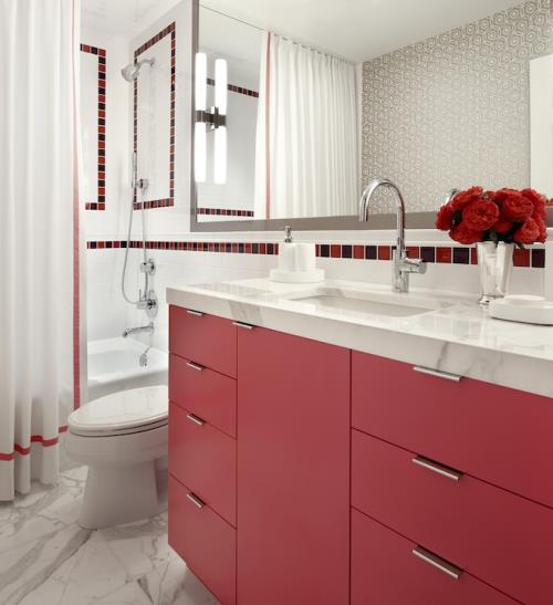 Μπάνιο σε κόκκινη κλασική εμφάνιση, λευκά έπιπλα μπάνιου, κόκκινη μονά ματαιοδοξία, μεγάλο καθρέφτη τοίχου, βάζο με κόκκινα λουλούδια