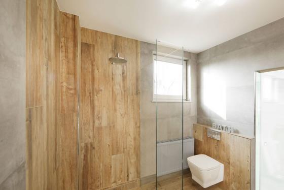 Πλακάκια μπάνιου σε ξύλινη εμφάνιση, όμορφο παράθυρο μπάνιου, φως ημέρας, ζεστή εμφάνιση
