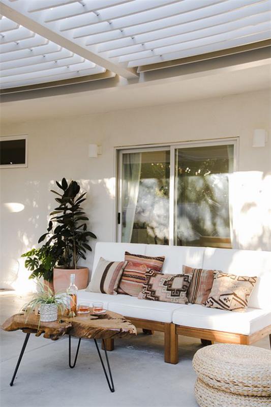 Βεράντα στυλ Boho Boho γωνιά χαλάρωσης στην καλυμμένη βεράντα δύο φυτά σε γλάστρες