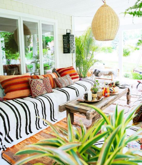 Κρεμαστό φωτιστικό βεράντας σε στιλ Boho από μπαστούνι από πολλά καταπράσινα διακοσμητικά μαξιλάρια έθνικ μοτίβο μακρύ καναπέ