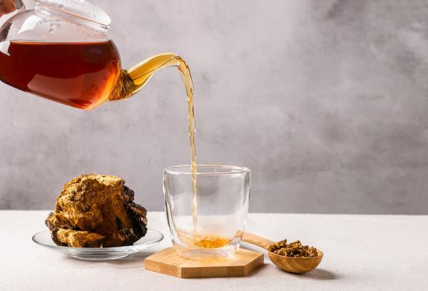 Τσάι Chaga Ρίξτε κομμάτια μανιταριών chaga από την κατσαρόλα στο φλιτζάνι