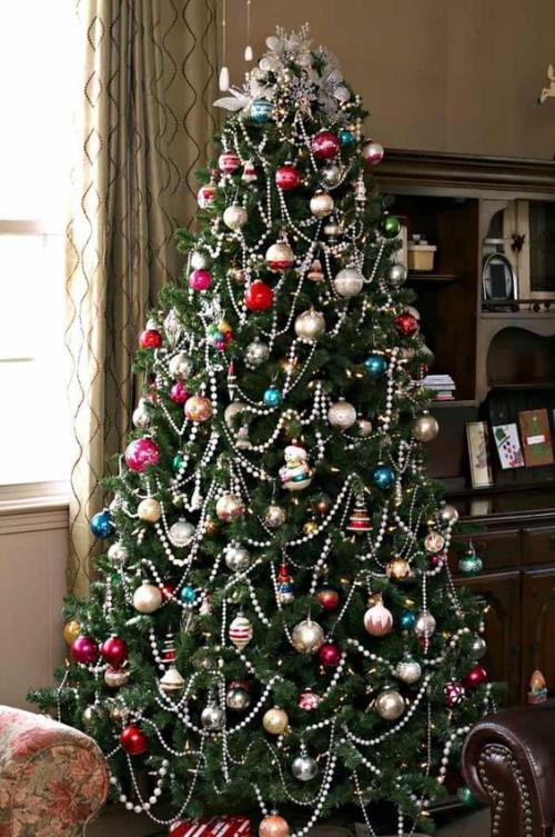Το χριστουγεννιάτικο δέντρο παραδοσιακά κοσμεί όμορφο πράσινο που τραβάει τα βλέμματα με πολύχρωμες μπάλες από ασημένιες γιρλάντες