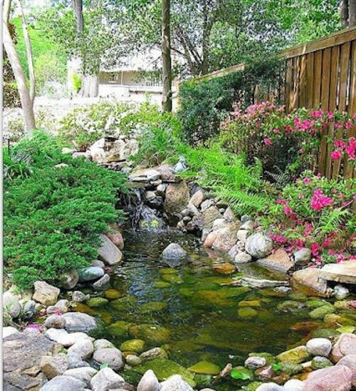 Δροσερή διακόσμηση κήπου λουλούδια πέτρες νερό ευχάριστο