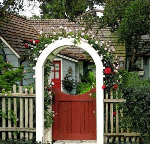 Δροσερό σχέδιο κήπου με κόκκινη πόρτα εισόδου με αψίδα τριαντάφυλλου