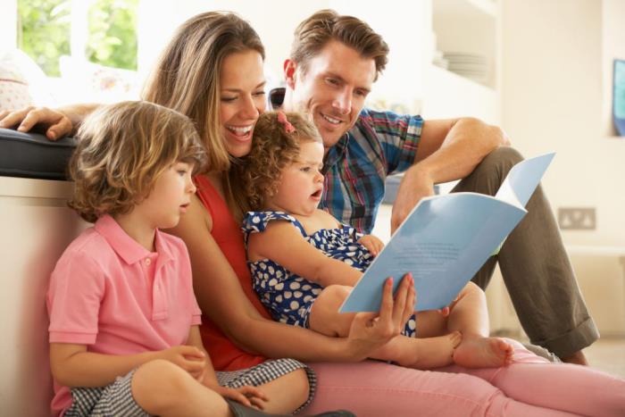 Κρίση Corona στο σπίτι τι κάνουν όλη η οικογένεια στον καναπέ διαβάζοντας ένα παιδικό βιβλίο διασκεδάζοντας