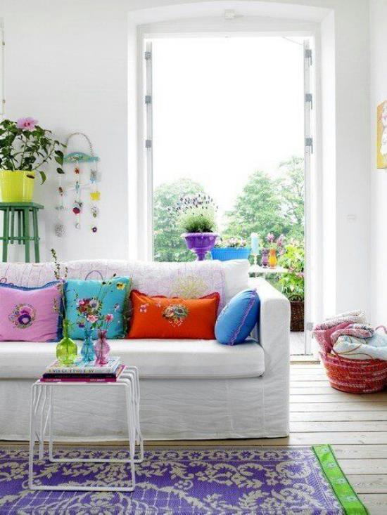 Ιδέες διακόσμησης σαλόνι λευκός καναπές πολύχρωμο ρίξτε μαξιλάρια ανοιχτή μπαλκονόπορτα φύση έξω