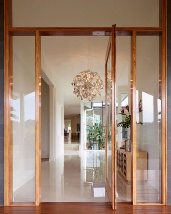 Οι περιστρεφόμενες πόρτες για τα ξύλινα κουφώματα του σπιτιού από γυαλί με κομψό σχεδιασμό επιτρέπουν την άφθονο φως της ημέρας να πλημμυρίσει