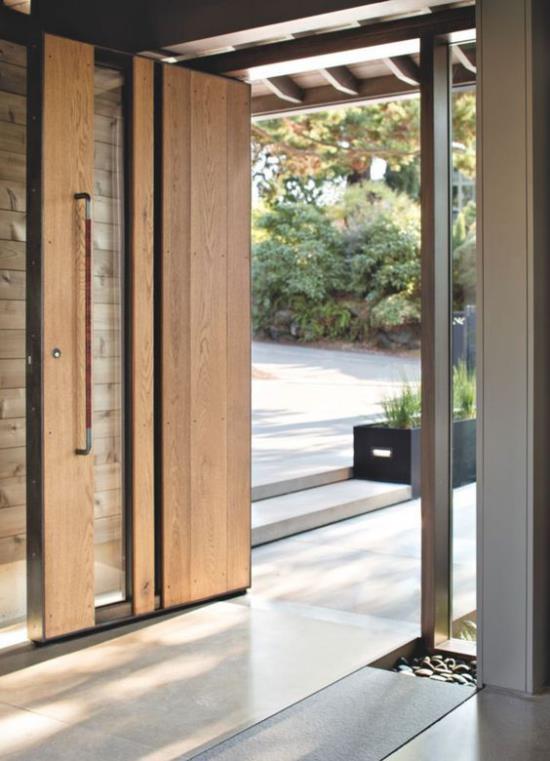 Περιστρεφόμενες πόρτες για το σπίτι Συνδυασμός ξύλου και γυαλιού στην έξοδο του σπιτιού στον κήπο