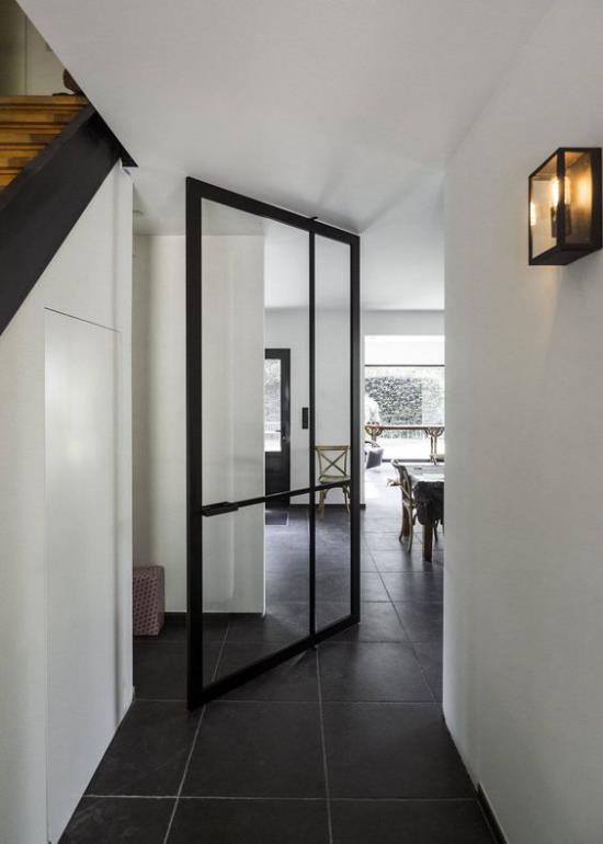 Περιστρεφόμενες πόρτες για το σπίτι στο εσωτερικό μαύρα μεταλλικά πλαίσια από γυαλί με θέα στο διπλανό δωμάτιο