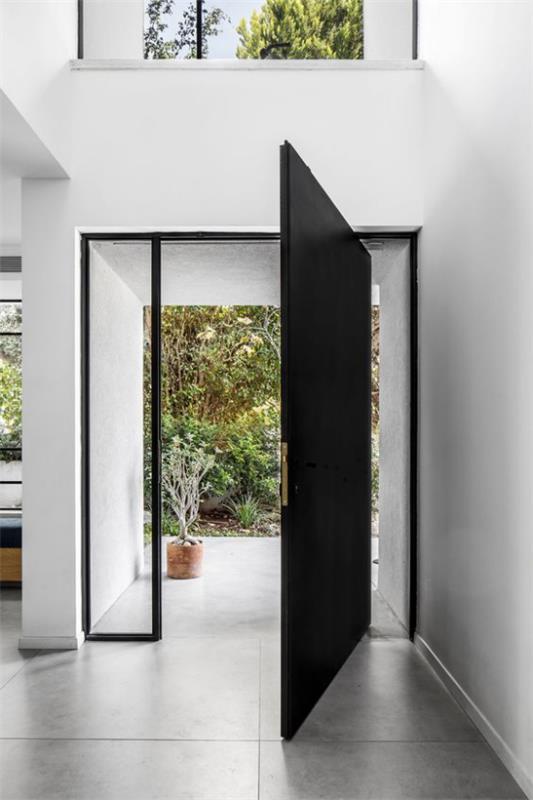 Περιστρεφόμενες πόρτες για το μοντέρνο μοντέρνο σπιτικό σχέδιο από μαύρο μέταλλο και γυαλί στην είσοδο του σπιτιού, ανθεκτικό στις καιρικές συνθήκες