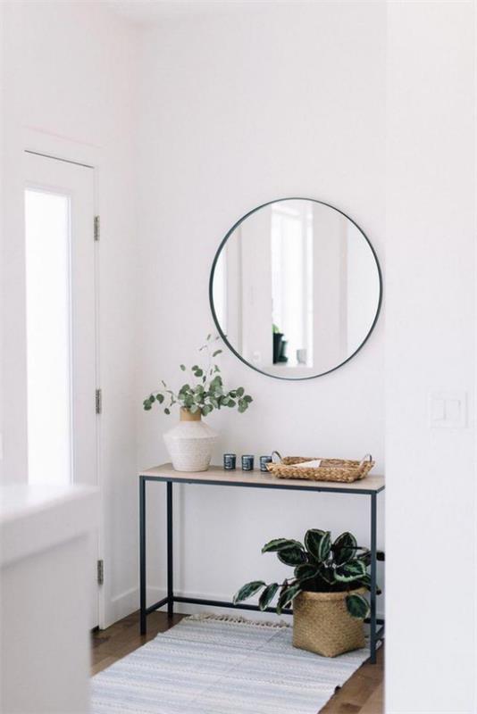 Χώρος εισόδου μοντέρνο σχέδιο απλό έπιπλο αίθουσας τραπέζι πράσινο φυτό λευκό βάζο με πράσινα κλαδιά ανοιχτό χαλί στρογγυλό καθρέφτη