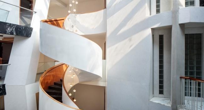 Μοναδικός σχεδιασμός σπιτιού Cleft House India New Delhi κομψή σπειροειδή σκάλα στο αίθριο διευκολύνει την πρόσβαση στους επάνω ορόφους
