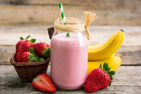 Το smoothie φράουλας μπανάνας σε ένα ποτήρι σε κάνει λεπτό και υγιές
