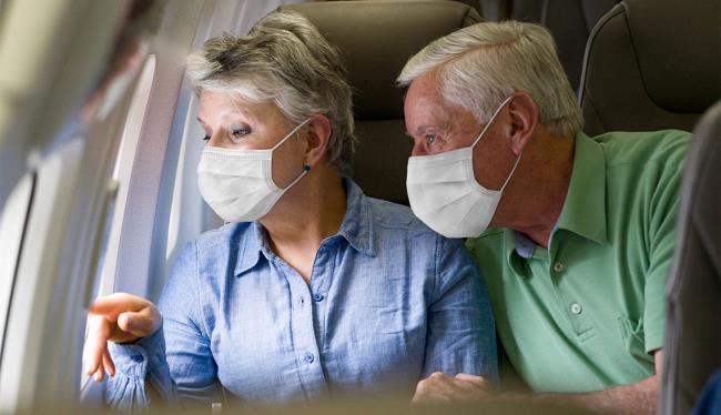 Πτήση κατά τη διάρκεια του Corona κίνδυνος μόλυνσης για ηλικιωμένους άνδρες άνδρες άνω των 65 ετών στο αεροπλάνο