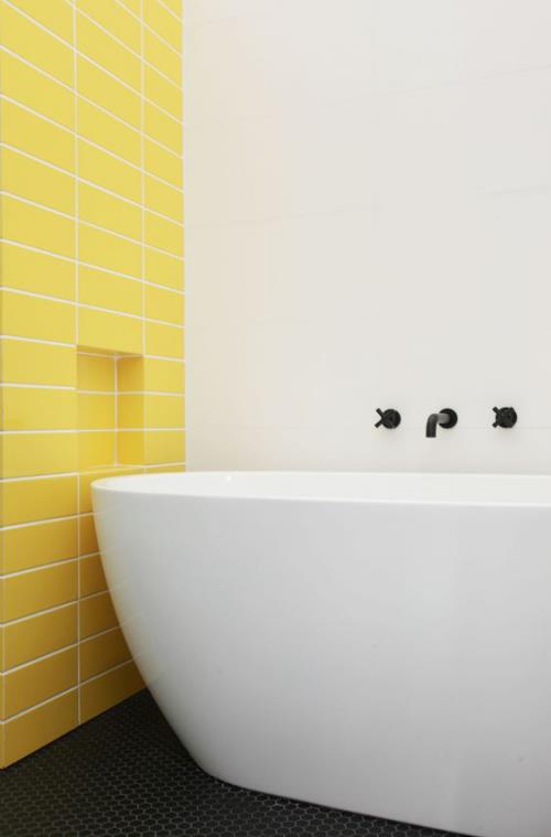 Πλακάκια στο μπάνιο δημιουργικός και τολμηρός τοίχος προφοράς σε ηλιόλουστο κίτρινο