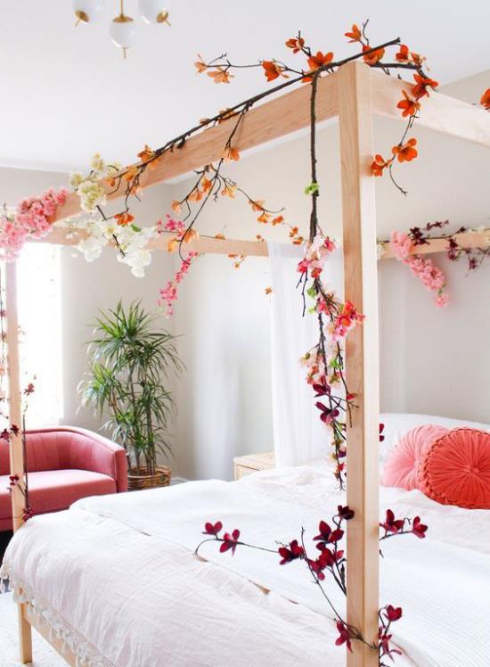 Ανοιξιάτικες ιδέες διακόσμησης για το υπνοδωμάτιο μεγάλο υπνοδωμάτιο ξύλινο πλαίσιο στολισμένο ανθισμένα κλαδιά ρομαντική διάθεση