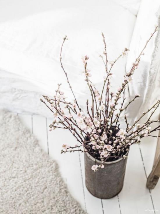 Ανοιξιάτικη διακόσμηση με άνθη κερασιάς λευκά λουλούδια στο παλιό σκεύος στο σαλόνι