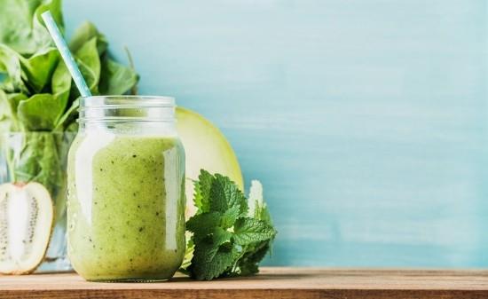 Φρεσκοφτιαγμένο πράσινο smoothie σε ποτήρι με άχυρο