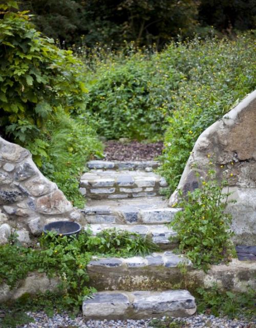 Μονοπάτια κήπου από πέτρα Φυσικό κήπο παχιά σκαλοπάτια από πέτρα κατάφυτη από φυτά