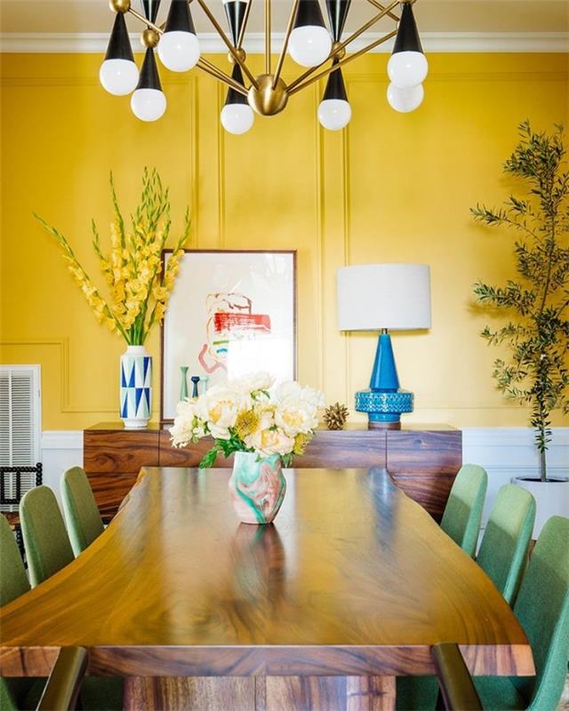 Τα μυστικά του εσωτερικού σχεδιασμού αποκαλύπτουν την τραπεζαρία σε έναν ζεστό, ηλιόλουστο κίτρινο, κίτρινο τοίχο, ανοιχτό πράσινες καρέκλες, κίτρινα γλαδιόλια σε ένα μεγάλο βάζο