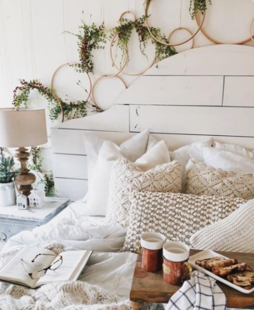 Άνετο υπνοδωμάτιο με χειμερινό σχεδιασμό πρωινό στο κρεβάτι μικρά πράσινα διακοσμητικά κλαδιά
