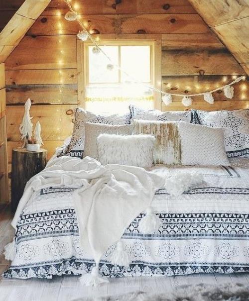 Το άνετο υπνοδωμάτιο το χειμώνα κάνει ρουστίκ ξύλινα διακοσμητικά μαξιλάρια από διακοσμητική αλυσίδα από faux γούνα