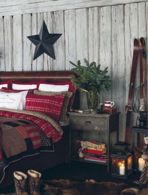 Τα άνετα υπνοδωμάτια το χειμώνα δημιουργούν ένα ρουστίκ αστέρι ατμόσφαιρας από σκούρο ξύλινο ξύλινο τοίχο, πολύχρωμα κλινοσκεπάσματα
